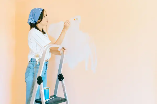 Interior painting in Cedar Rapids: painter on a stepladder rolling a wall